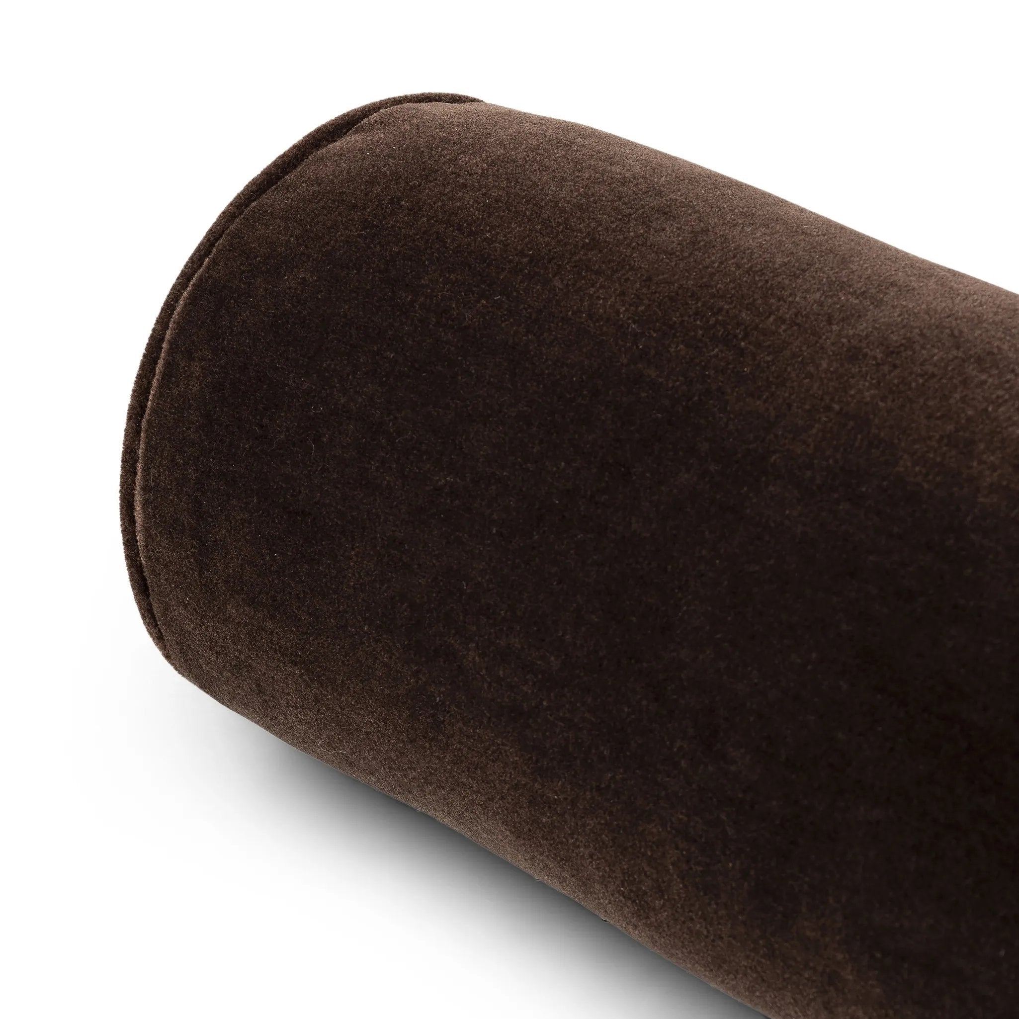 A long, chocolate-colored bolster pillow elevates beds and sofas in an instant. Crafted from saturated wool velvet, for a sustainable alternative to mohair, with a hidden zipper for a smooth silhouette Amethyst Home provides interior design, new home construction design consulting, vintage area rugs, and lighting in the Houston metro area.