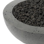 This outdoor fire table is a welcoming centerpiece designed for gathering. Made from glass-reinforced concrete, each piece is naturally finished with deep tones of pewter and dark grey. The bowl shape is completed with lavastones in the center, bringing together a bold, monochromatic look. Amethyst Home provides interior design, new home construction design consulting, vintage area rugs, and lighting in the Salt Lake City metro area.