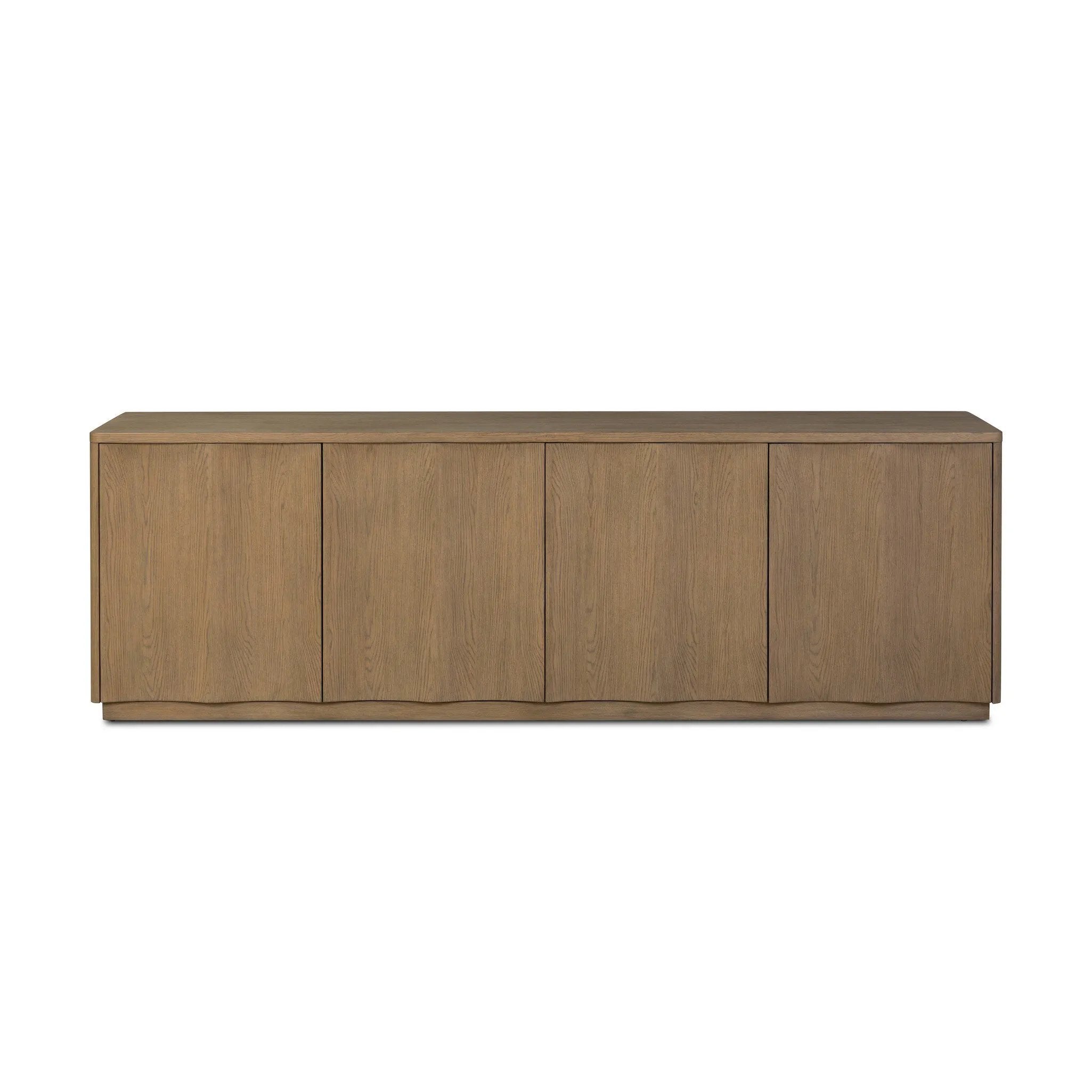 The traditional media console, reimagined. This warm oak piece features two sets of doors with shallow scalloping that draws the eye, providing a subtle visual flow. Rear cutouts for cord management.As lovers of natural aesthetics at Amethyst, we love the designer inspired Brookhurst Media Console - Drifted Oak Veneer. Amethyst Home provides interior design, new home construction design consulting, vintage area rugs, and lighting in the Salt Lake City metro area.
