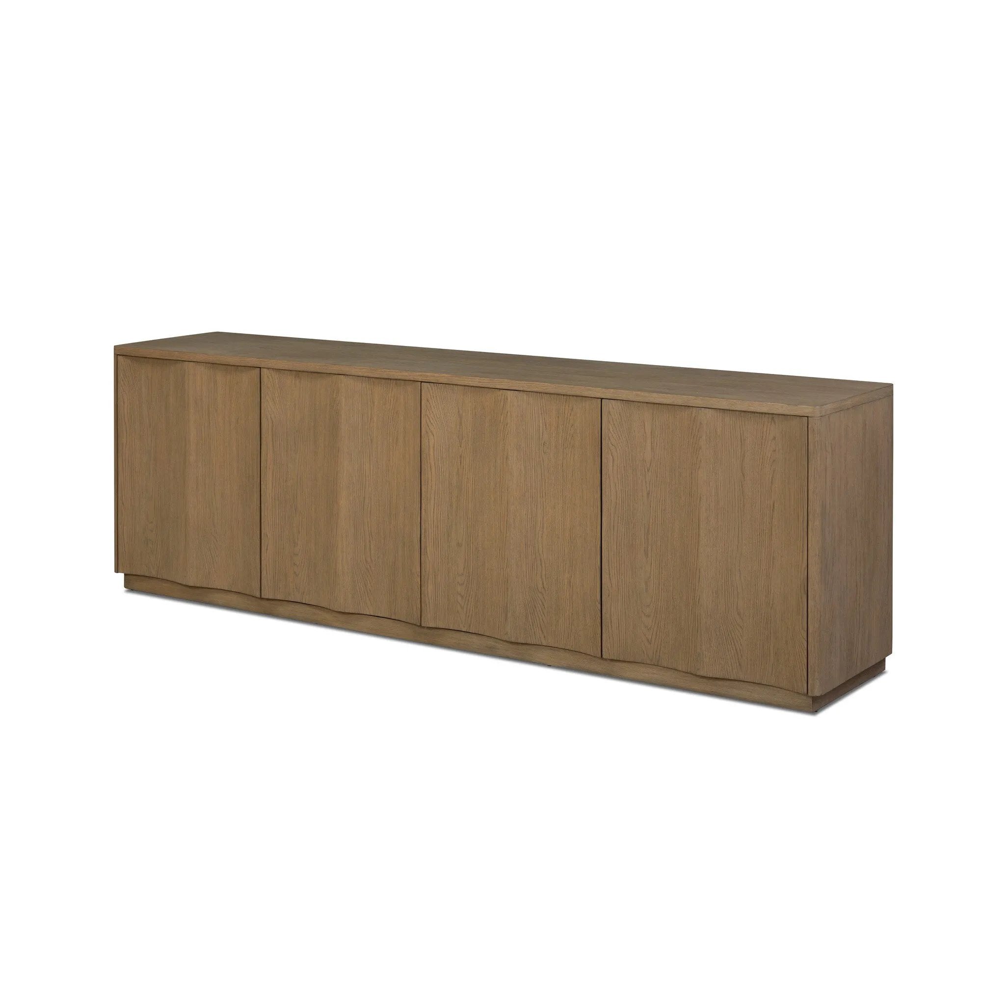 The traditional media console, reimagined. This warm oak piece features two sets of doors with shallow scalloping that draws the eye, providing a subtle visual flow. Rear cutouts for cord management.As lovers of natural aesthetics at Amethyst, we love the designer inspired Brookhurst Media Console - Drifted Oak Veneer. Amethyst Home provides interior design, new home construction design consulting, vintage area rugs, and lighting in the Washington metro area.