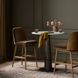 Solid ash wood forms a subtly curved back on this everyday counter stool. Its open frame and seat features rounded edges for 