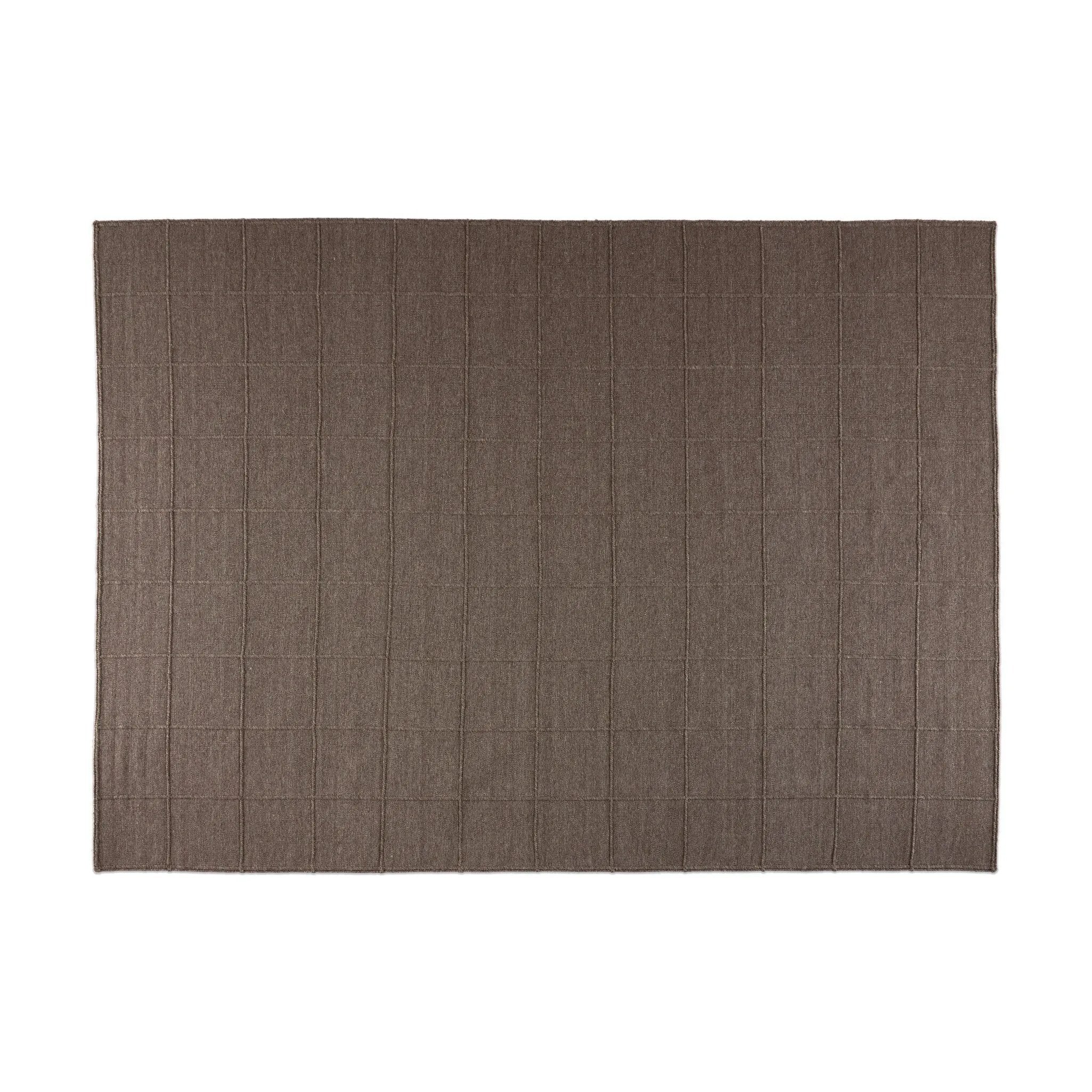 Hand woven in a flat weave grid pattern for the look of an indoor textile, this  mineral-hued rug grounds the outdoor lounge with a high-texture look. Slight variation in sizing and imperfect lines due to the handcrafted nature of each piece are to be expected. Store inside during inclement weather and when not in use. Amethyst Home provides interior design, new home construction design consulting, vintage area rugs, and lighting in the Newport Beach metro area.