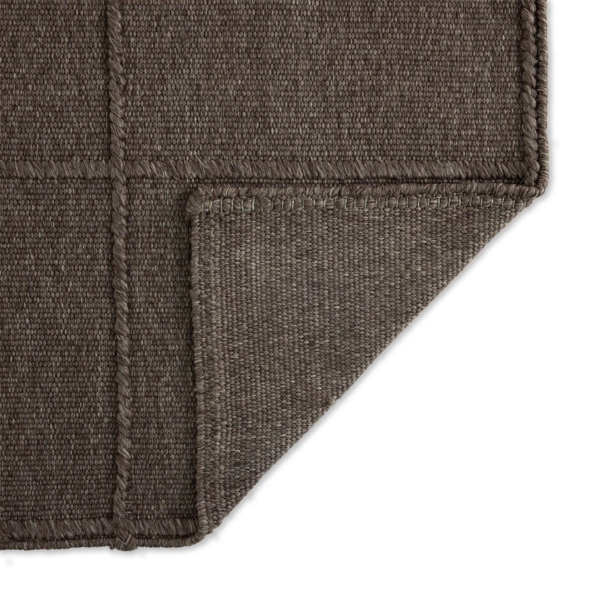 Hand woven in a flat weave grid pattern for the look of an indoor textile, this  mineral-hued rug grounds the outdoor lounge with a high-texture look. Slight variation in sizing and imperfect lines due to the handcrafted nature of each piece are to be expected. Store inside during inclement weather and when not in use. Amethyst Home provides interior design, new home construction design consulting, vintage area rugs, and lighting in the Park City metro area.