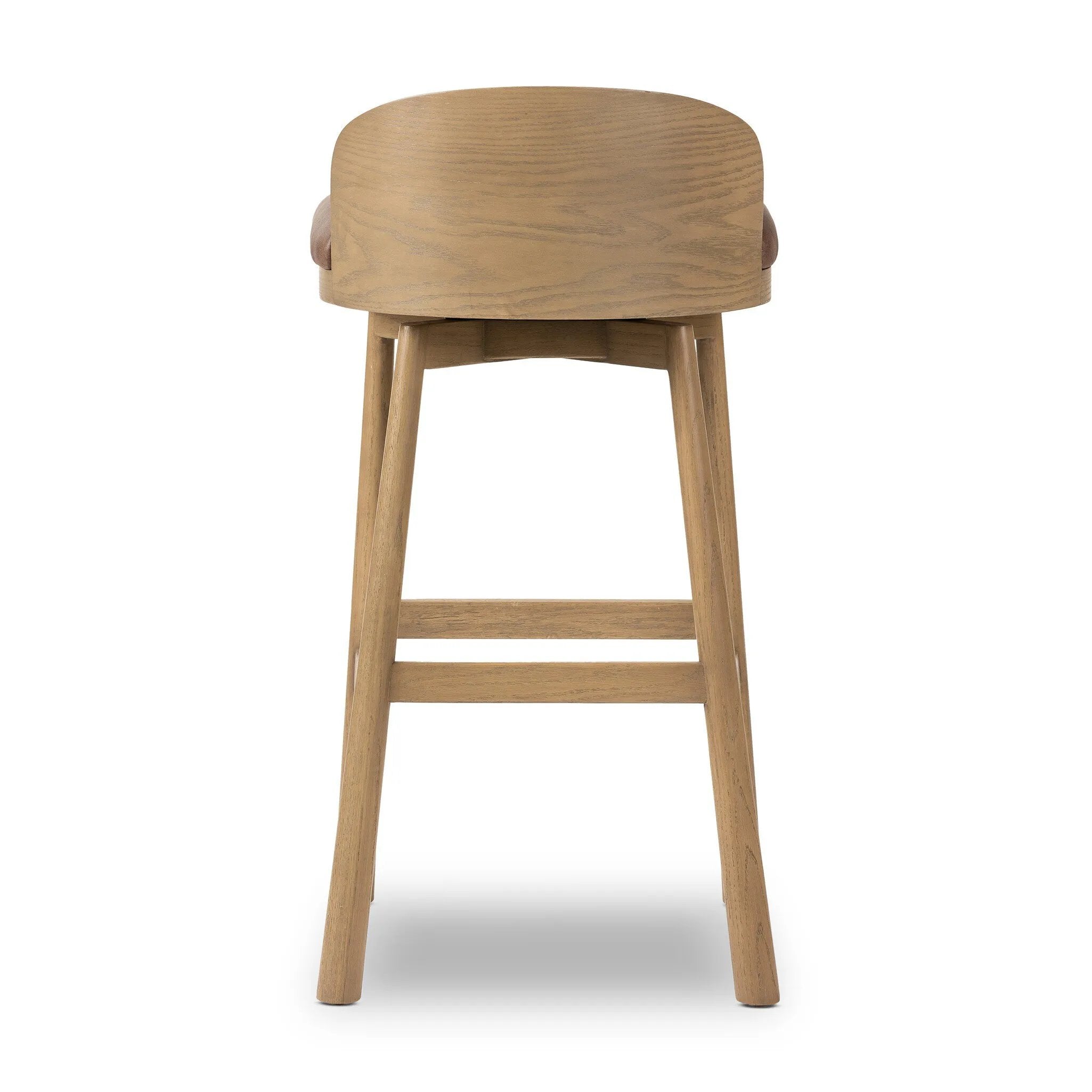 Featuring Cloris Palermo Cigar Swivel Bar + Counter Stool by Four Hands at Amethyst Home. Channel vintage vibes with a swivel stool perfectly sized for the bar. Crafted of blonde-finished oak, a low, molded back adds a playful touch, while a top-grain leather seat offers luxe comfort. Finished off with a memory swivel to ensure the stool's curved wood back. Amethyst Home provides interior design, new home construction design consulting, vintage area rugs, and lighting in the Washington metro area.