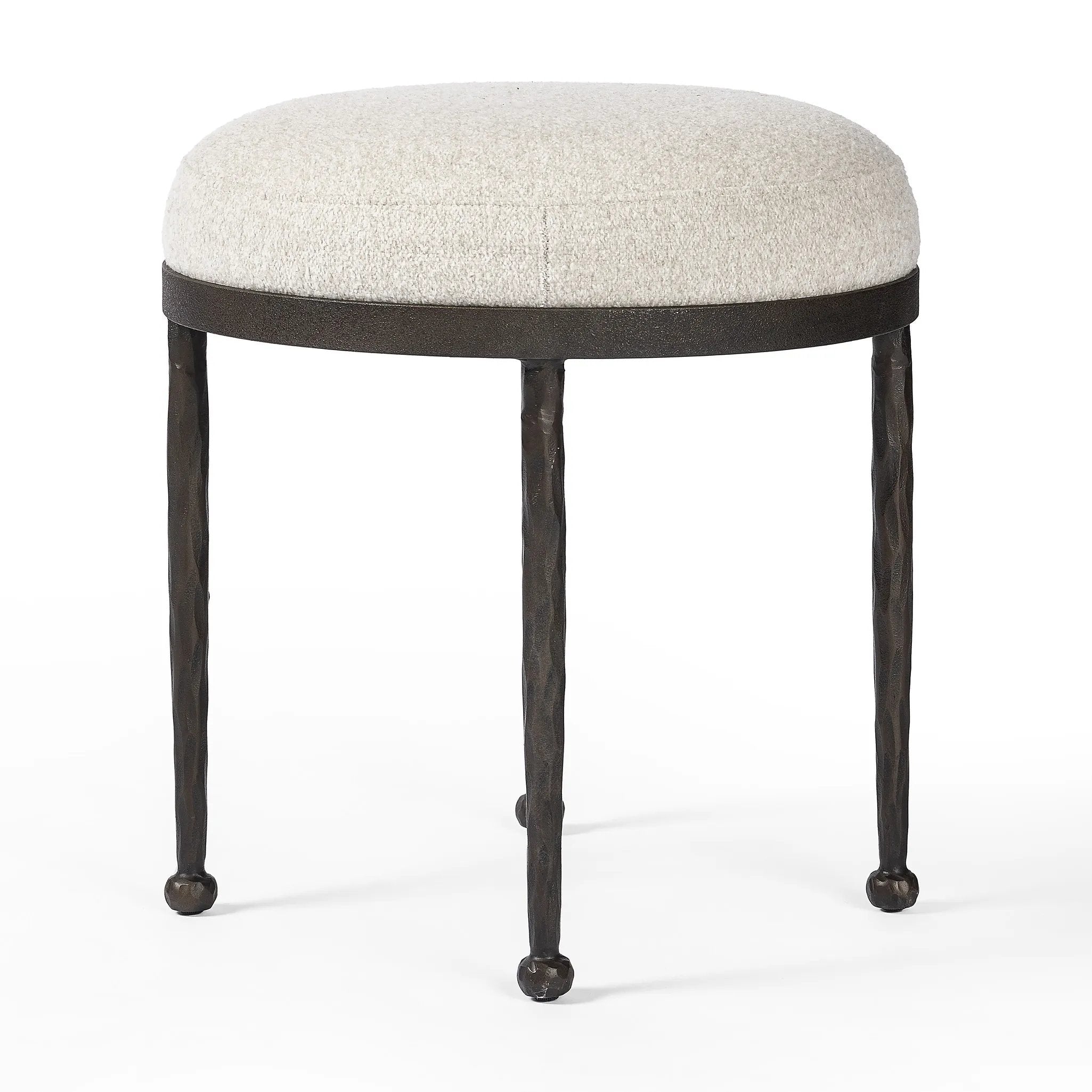 Work midcentury vibes into any space with a pared-back accent stool that doubles as a cocktail ottoman. Wrough iron legs finished in a hammered bronze pair with a simple rounded seat upholstered in a texture-rich fabric, with S-spring suspension for comfort and structure Amethyst Home provides interior design, new home construction design consulting, vintage area rugs, and lighting in the Salt Lake City metro area.