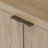 Featuring Cristopher Rubbed Light Oak Veneer Sideboard by Four Hands at Amethyst Home. A playful placement of rounded shapes and clean lines, this sideboard captivates with half-cylinder legs seamlessly blending into the storage case and top, complete with curved metal hardware. Finished in light oak for warm, light look that can move between styles with e. Amethyst Home provides interior design, new home construction design consulting, vintage area rugs, and lighting in the Des Moines metro area.
