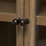 Featuring Dawes Weathered Oak Cabinet by Four Hands at Amethyst Home. Work the timeless charm of a vintage find into your collection. Weathered oak cabinetry features softened mullions and rounded glass panels, with aged bronze barrel hinges and finial detailing. Generous storage and display options  empower you to create a space that tells your story.Ove. Amethyst Home provides interior design, new home construction design consulting, vintage area rugs, and lighting in the Los Angeles metro area.