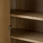 Crafted from light oak with a plinth-style base, rounded sides and linear reeding, this tall cabinet works subtle midcentury vibes into any space. Fully finished interior and shelves for quality detailing inside and out Amethyst Home provides interior design, new home construction design consulting, vintage area rugs, and lighting in the Houston metro area.