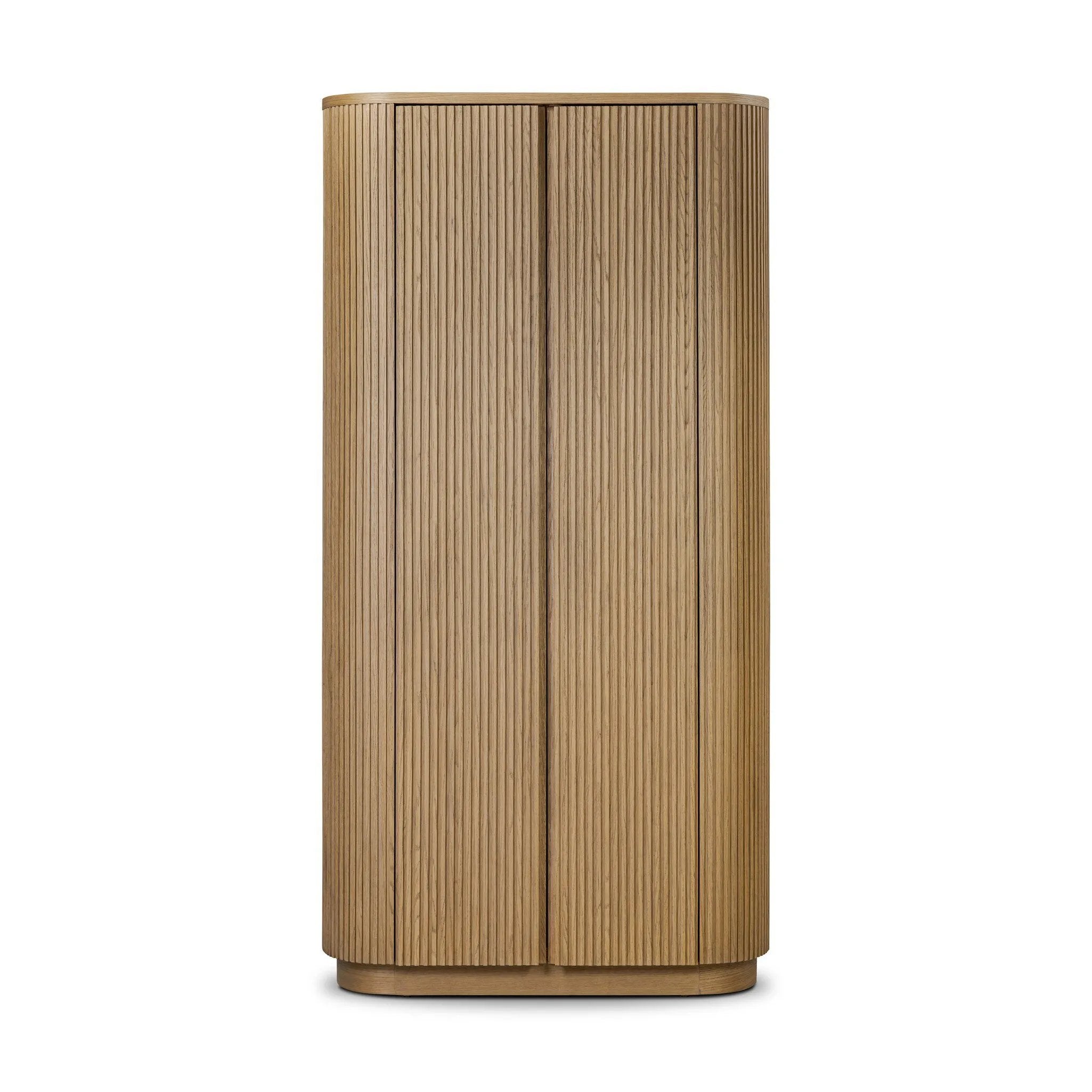 Crafted from light oak with a plinth-style base, rounded sides and linear reeding, this tall cabinet works subtle midcentury vibes into any space. Fully finished interior and shelves for quality detailing inside and out Amethyst Home provides interior design, new home construction design consulting, vintage area rugs, and lighting in the Newport Beach metro area.