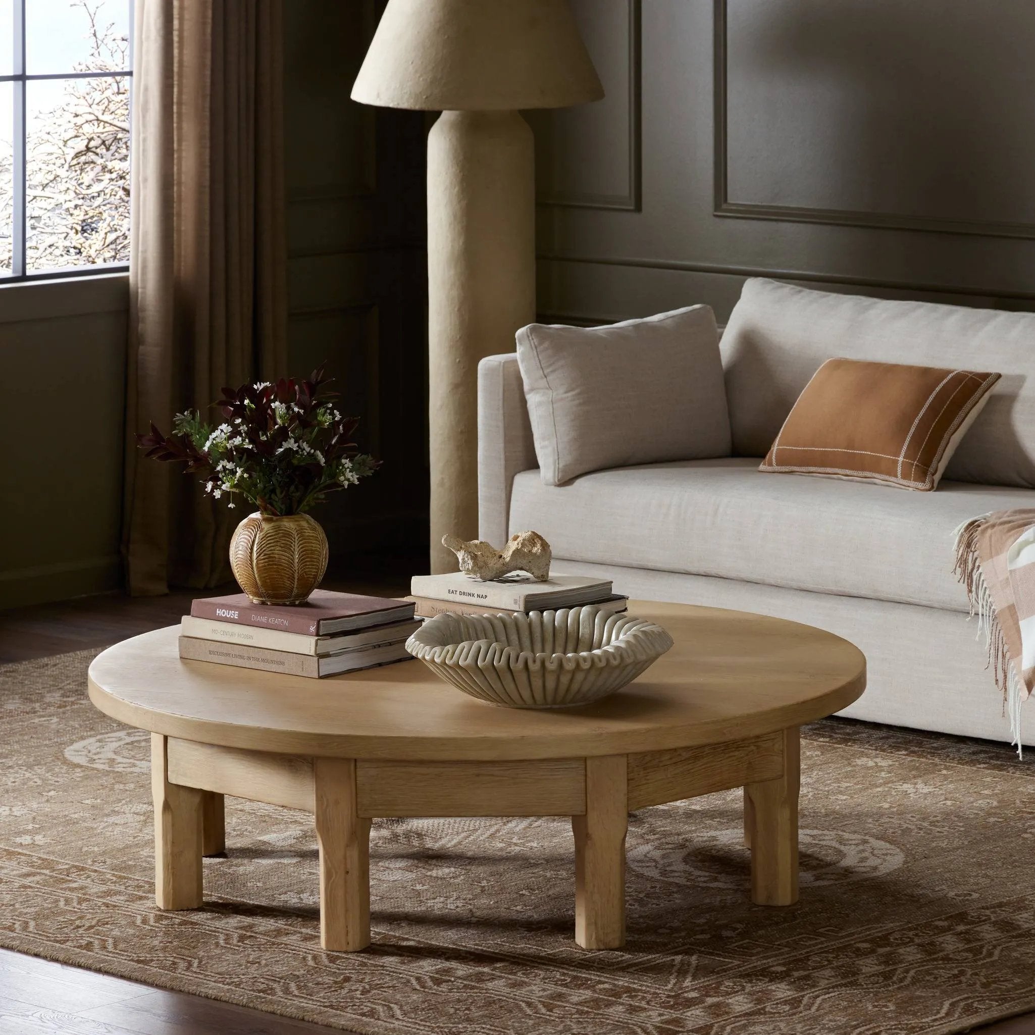 Made from bleached oak, a unique eight-leg base supports a rounded tabletop. Inspired by a "found object" aesthetic, this piece works a nomadic vibe into any room Amethyst Home provides interior design, new home construction design consulting, vintage area rugs, and lighting in the Charlotte metro area.