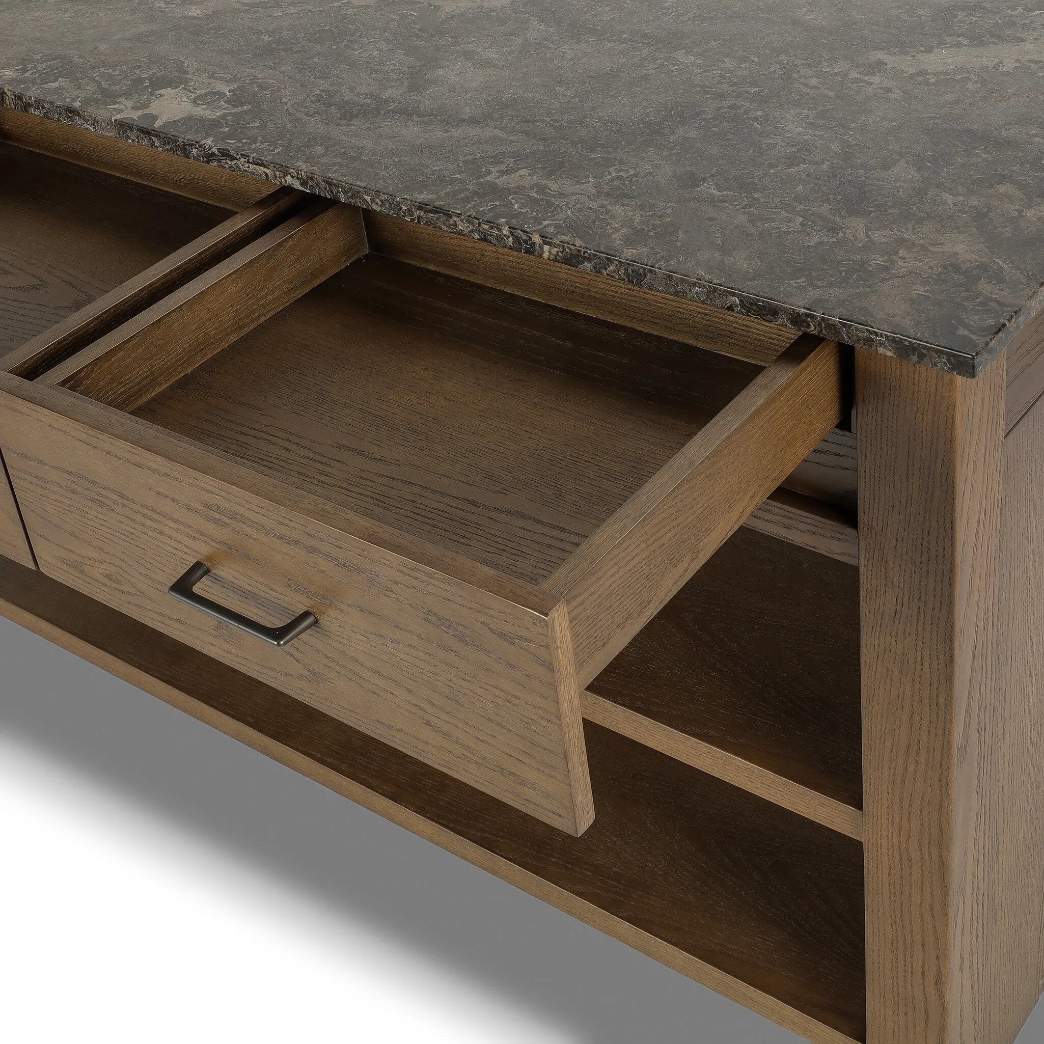A kitchen island and waterfall dining table in one. Crafted from oak, the island system features two large shelves and three drawers on each side, all  topped with by warm grey marble. The pullout table extends and fits inside the frame with ease Amethyst Home provides interior design, new home construction design consulting, vintage area rugs, and lighting in the Park City metro area.
