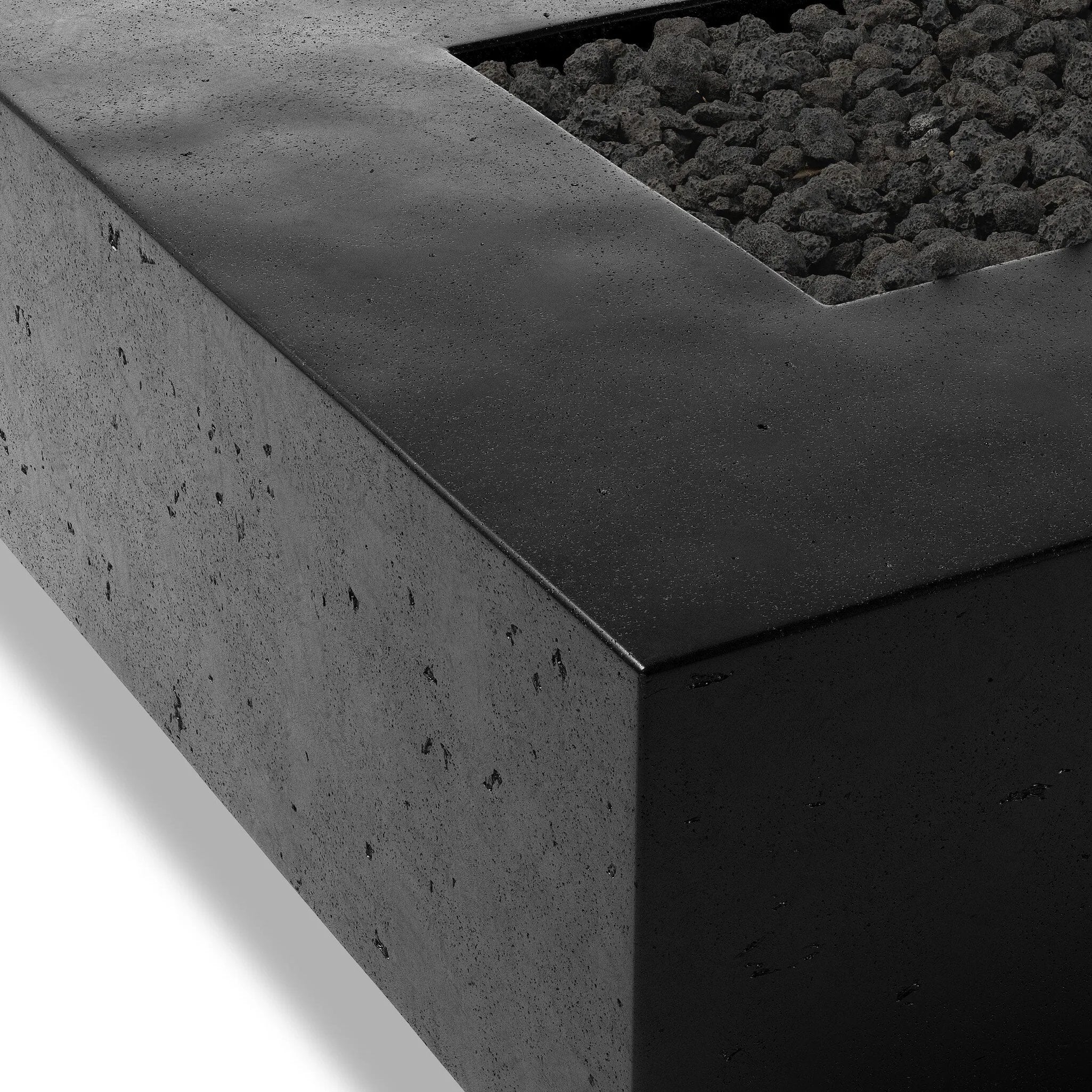 This outdoor fire table is a welcoming centerpiece designed for gathering. Made from glass-reinforced concrete, each piece is naturally finished with deep tones of charcoal. The monolithic shape is completed with lavastones in the center, bringing together a bold, monochromatic look. Amethyst Home provides interior design, new home construction design consulting, vintage area rugs, and lighting in the Salt Lake City metro area.