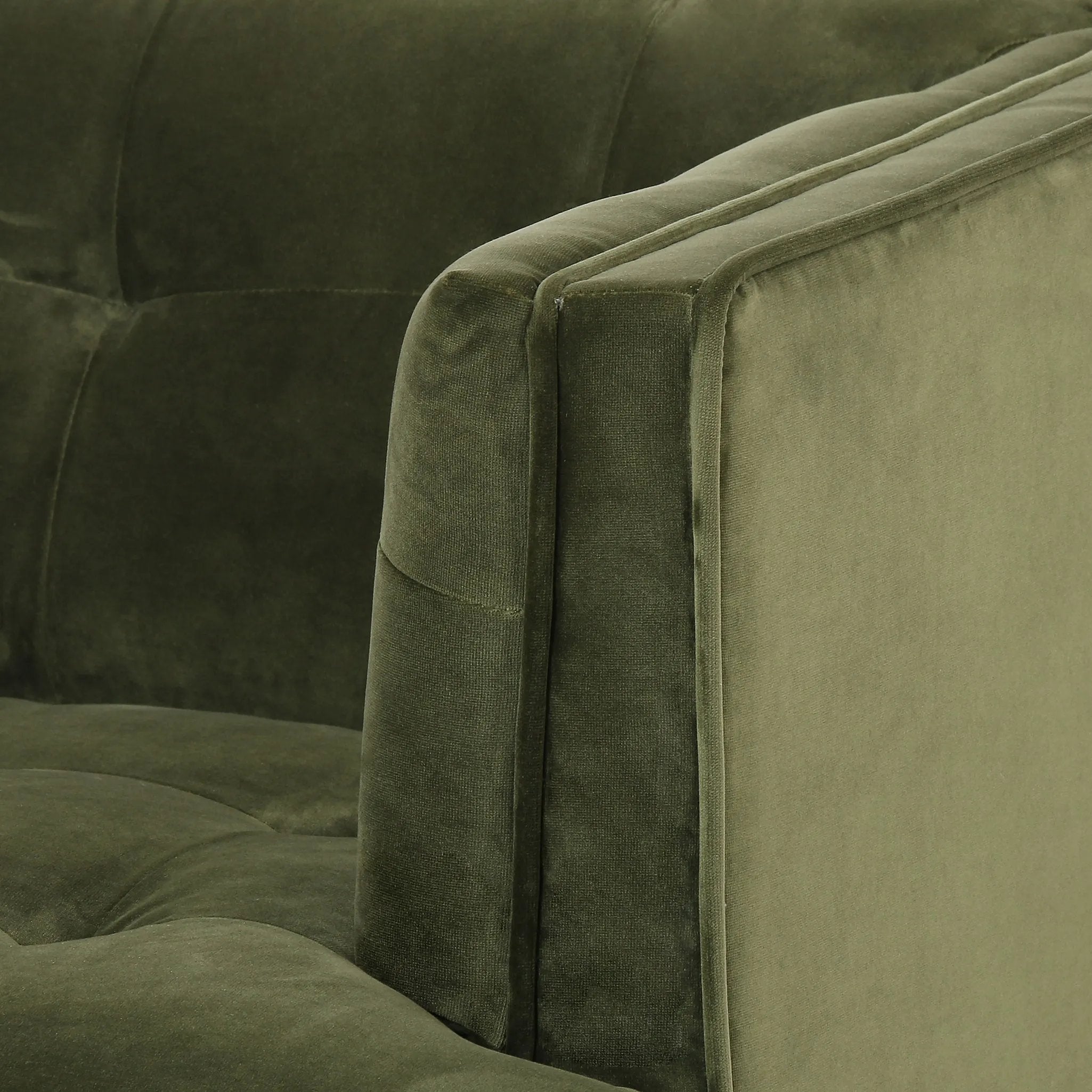 A low, spacious mid-century silhouette is covered in velvety upholstery in an intriguing sapphire olive, with blind tufting Amethyst Home provides interior design, new home construction design consulting, vintage area rugs, and lighting in the Dallas metro area.
