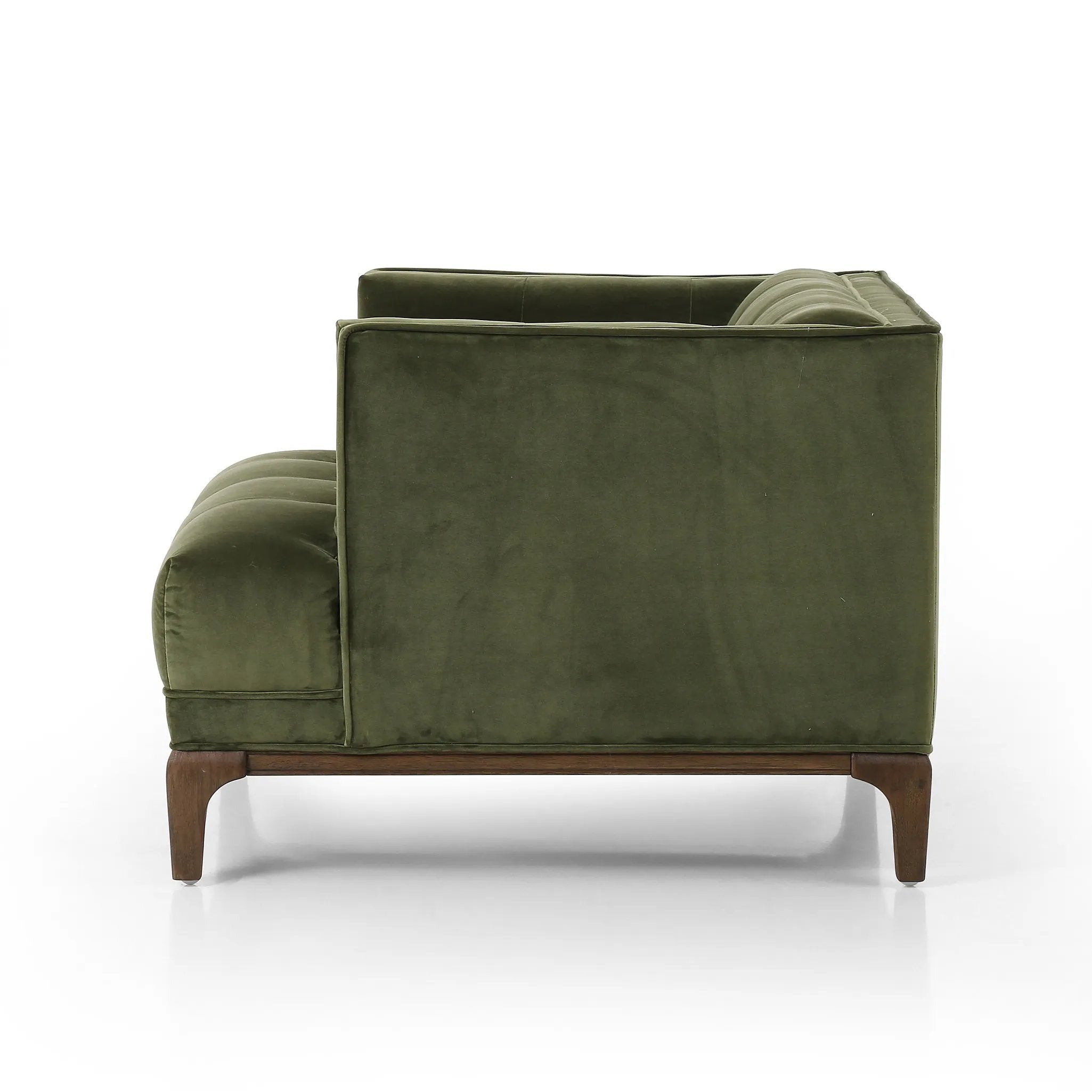 A low, spacious mid-century silhouette is covered in velvety upholstery in an intriguing sapphire olive, with blind tufting Amethyst Home provides interior design, new home construction design consulting, vintage area rugs, and lighting in the Omaha metro area.