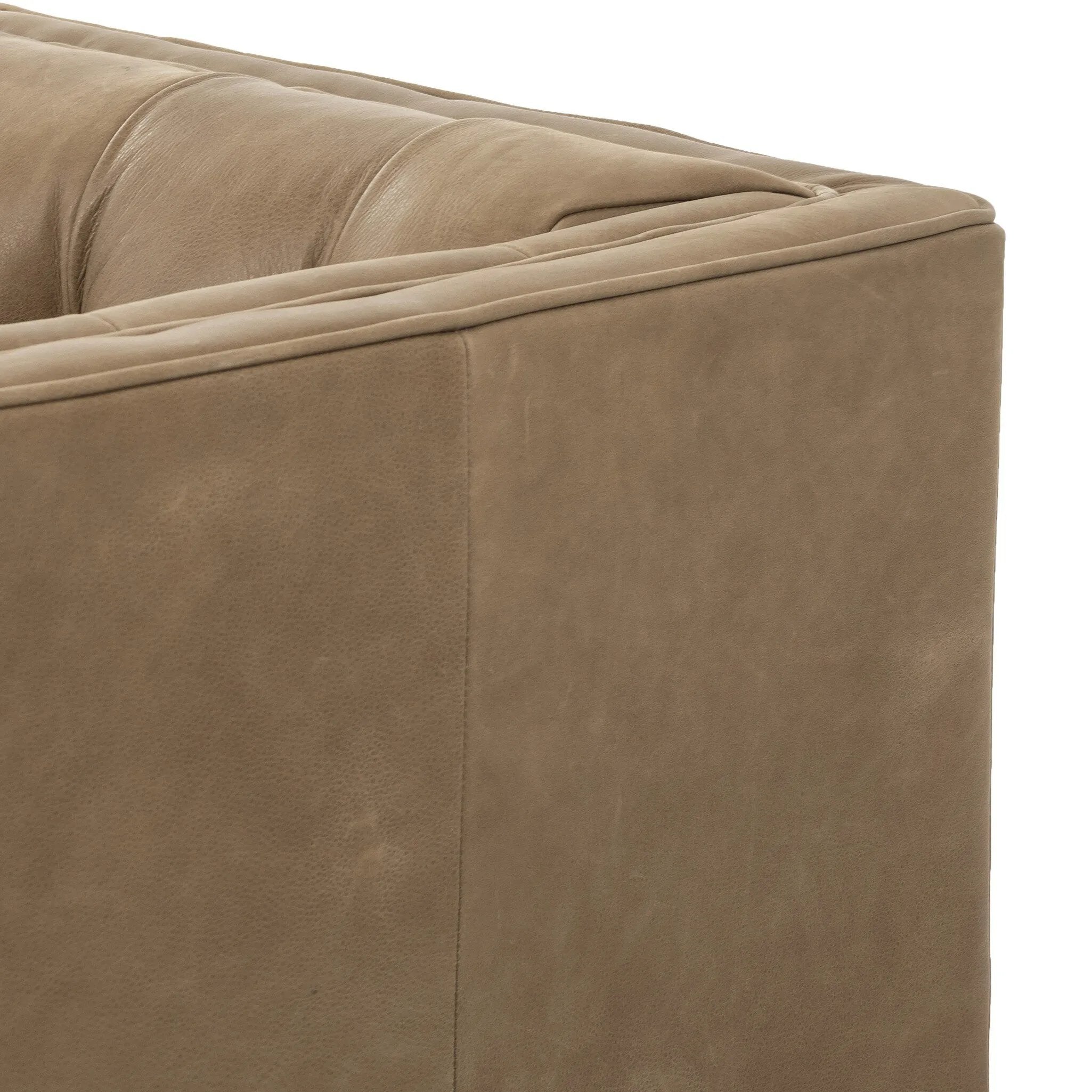 A modernized midcentury silhouette meets the traditional Chesterfield sofa, all in a compact profile perfect for smaller spaces. Top-grain leather in a tan hue, button tufting and a smooth touch bring deep comfort to lounging Amethyst Home provides interior design, new home construction design consulting, vintage area rugs, and lighting in the Boston metro area.