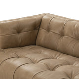 A modernized midcentury silhouette meets the traditional Chesterfield sofa, all in a compact profile perfect for smaller spaces. Top-grain leather in a tan hue, button tufting and a smooth touch bring deep comfort to lounging Amethyst Home provides interior design, new home construction design consulting, vintage area rugs, and lighting in the Dallas metro area.