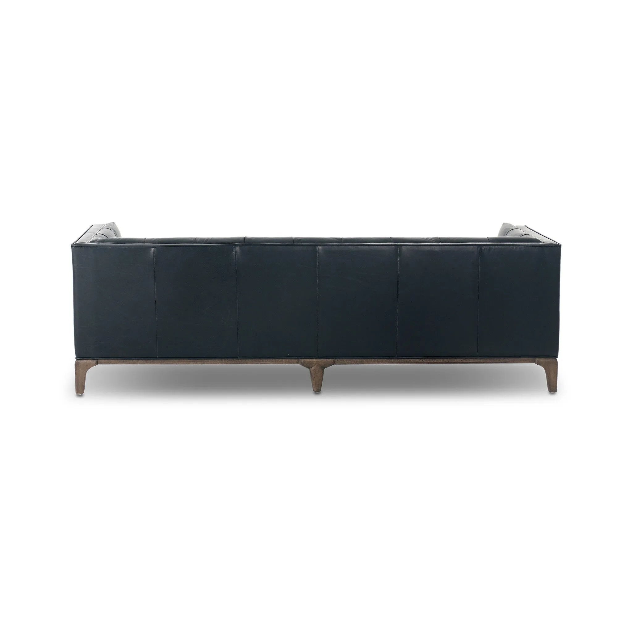 A modernized midcentury silhouette meets the traditional Chesterfield sofa, all in a compact profile perfect for smaller spaces. Top-grain leather in a classic black, button tufting and a smooth touch bring deep comfort to lounging Amethyst Home provides interior design, new home construction design consulting, vintage area rugs, and lighting in the Dallas metro area.