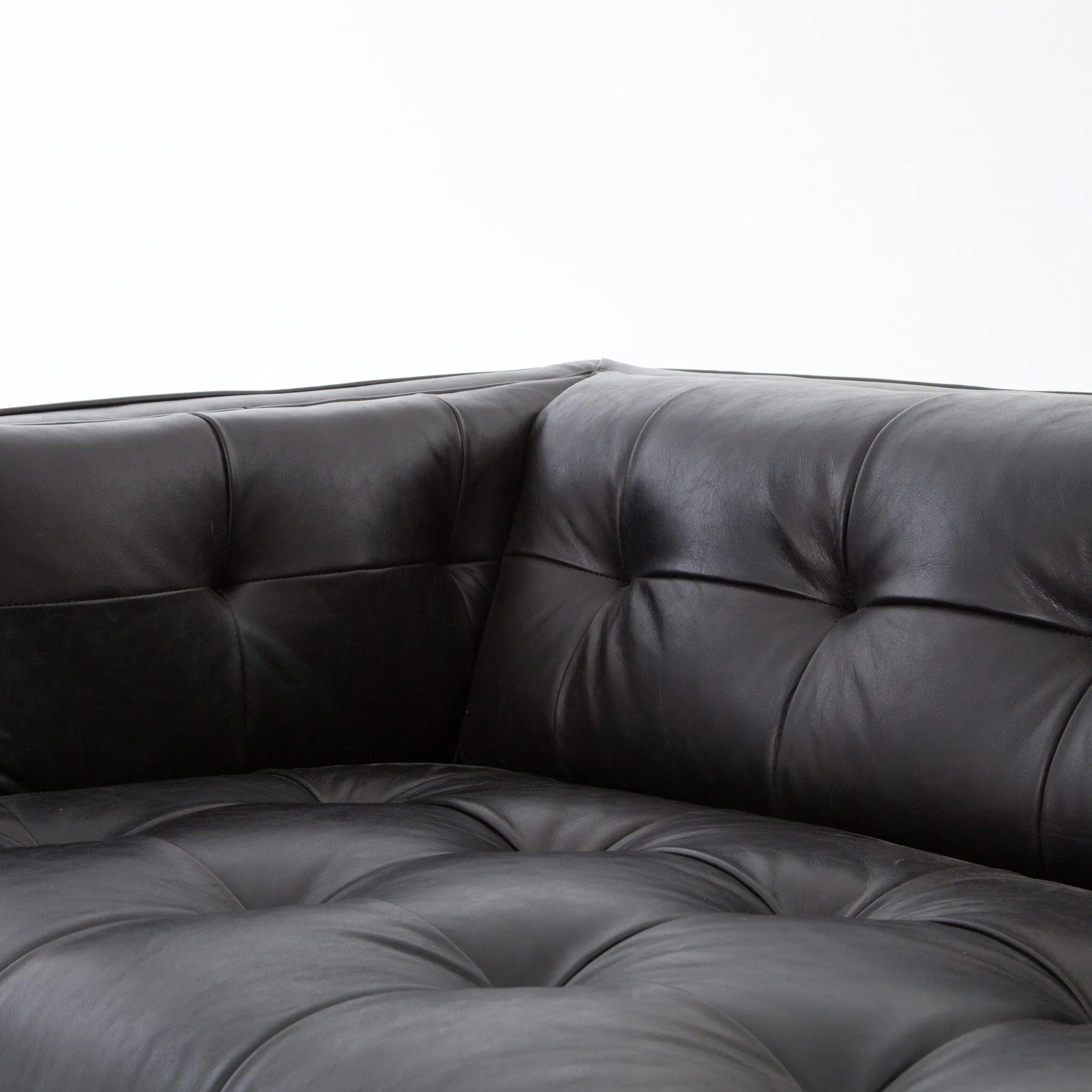 A modernized midcentury silhouette meets the traditional Chesterfield sofa, all in a compact profile perfect for smaller spaces. Top-grain leather in a classic black, button tufting and a smooth touch bring deep comfort to lounging Amethyst Home provides interior design, new home construction design consulting, vintage area rugs, and lighting in the Winter Garden metro area.
