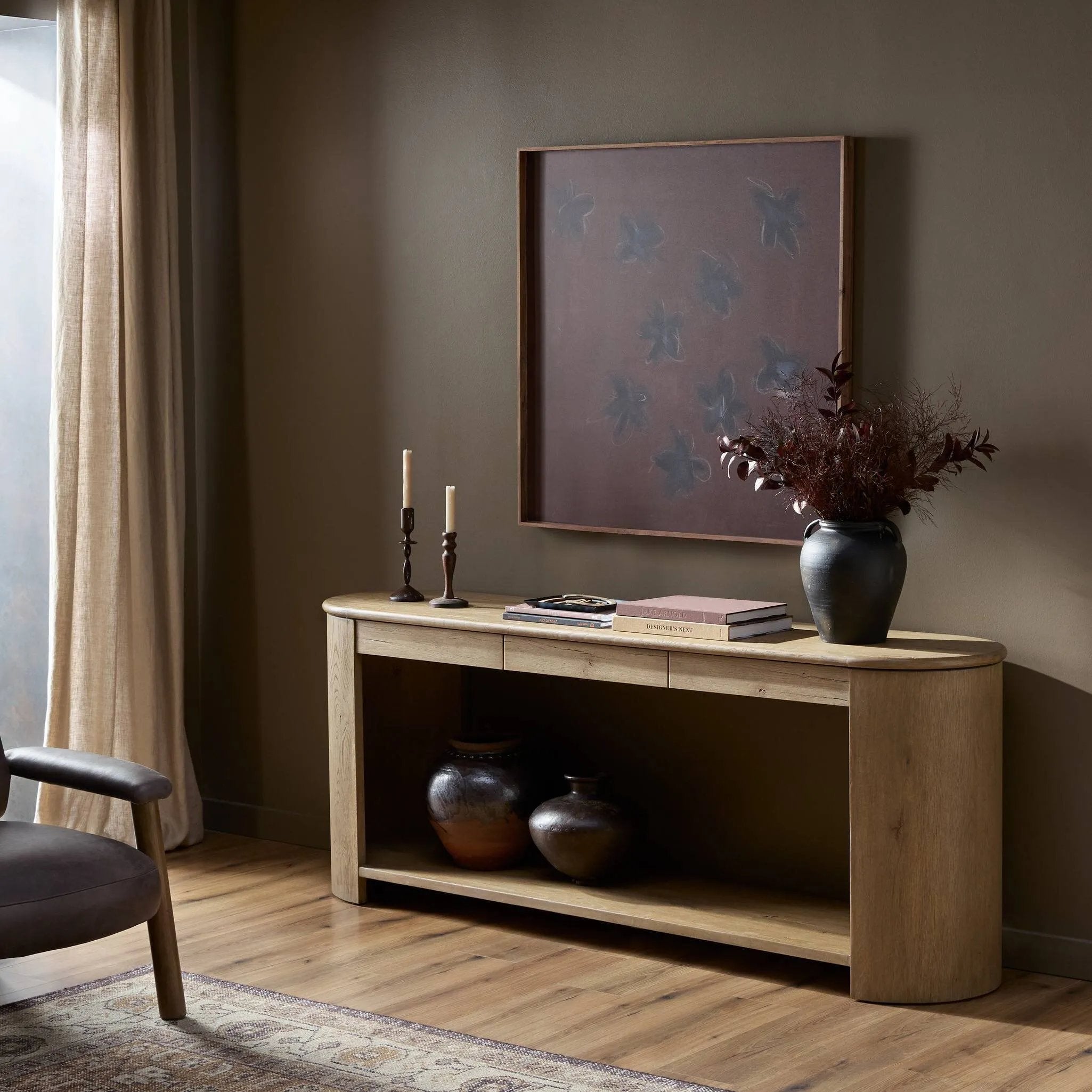 A simple pill-shaped console table, refreshed with intriguing design details. Made from warm, light-finished oak, open lower shelving creates endless storage and styling options for your living or media room. Three drawers bring even more storage, while bullnose and relief detailing adds an artisan touch to this piece Amethyst Home provides interior design, new home construction design consulting, vintage area rugs, and lighting in the Alpharetta metro area.