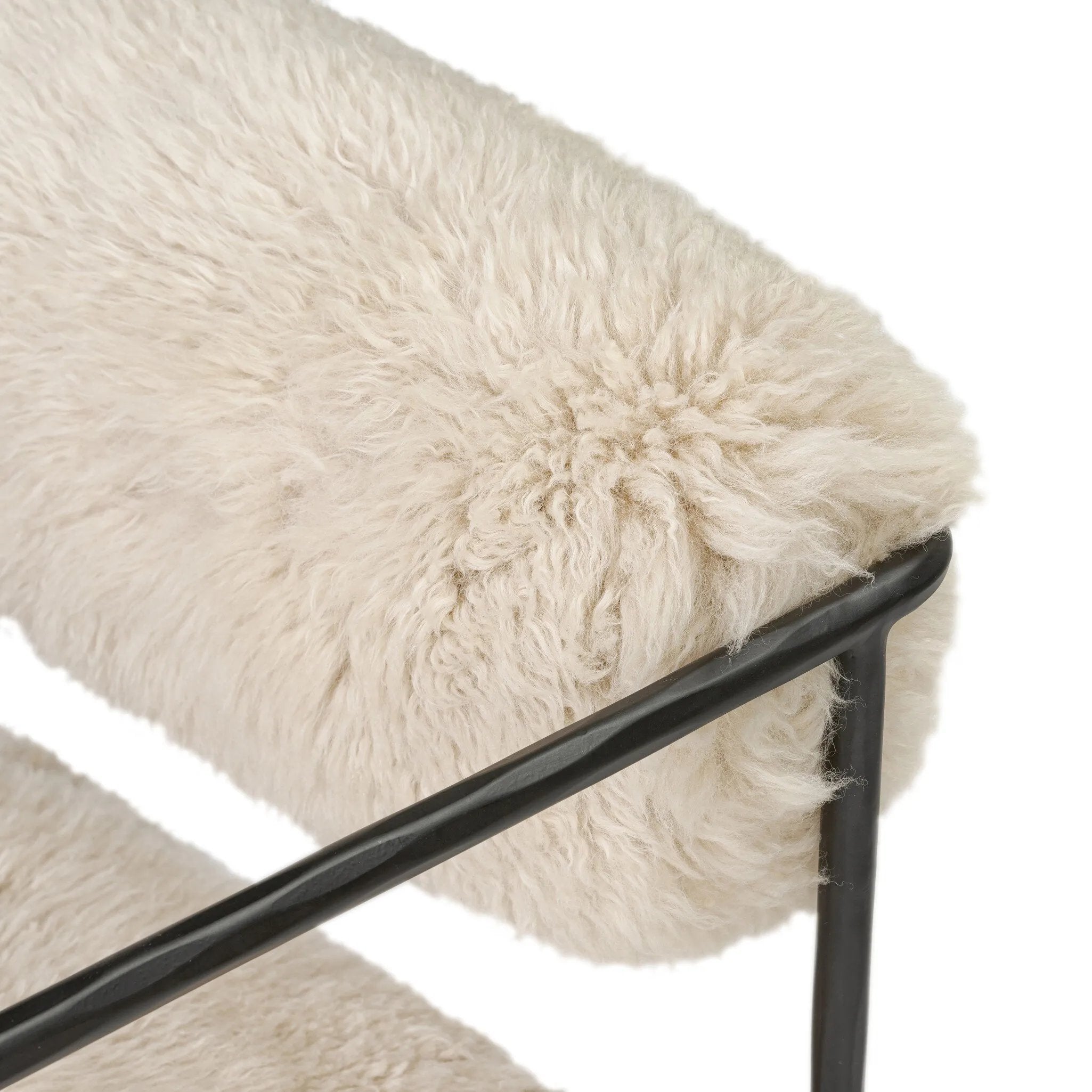 A textural take on a timeless silhouette. Hammered iron frames a squared seat and bolster back upholstered in off-white Mongolian fur Amethyst Home provides interior design, new home construction design consulting, vintage area rugs, and lighting in the Houston metro area.
