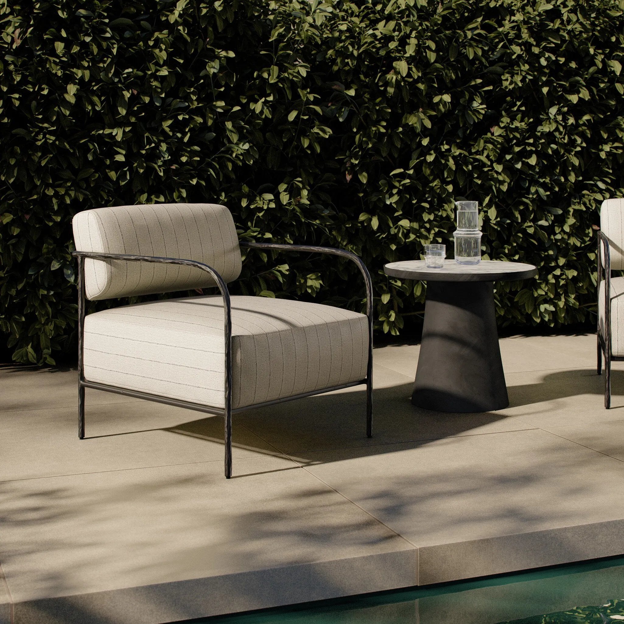 A slim take on a timeless silhouette. Hammered iron frames a squared seat and bolster back upholstered in striped, neutral fabric. Cover or store inside during inclement weather and when not in use.As enthusiasts of organic modern style at Amethyst, we love the nature inspired Fenn Outdoor Chair - Amalfi Natural. Amethyst Home provides interior design, new home construction design consulting, vintage area rugs, and lighting in the Boston metro area.