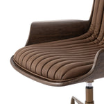 Elevate the office with one easy piece. Inspired by midcentury molded plywood chairs, brown oak veneer frames top-grain leather seat cushioning with slim, soft channeling. A 360-degree swivel burnished brass-finished base with casters allows for easy movement. Amethyst Home provides interior design, new home construction design consulting, vintage area rugs, and lighting in the Calabasas metro area.