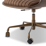Elevate the office with one easy piece. Inspired by midcentury molded plywood chairs, brown oak veneer frames top-grain leather seat cushioning with slim, soft channeling. A 360-degree swivel burnished brass-finished base with casters allows for easy movement. Amethyst Home provides interior design, new home construction design consulting, vintage area rugs, and lighting in the Seattle metro area.