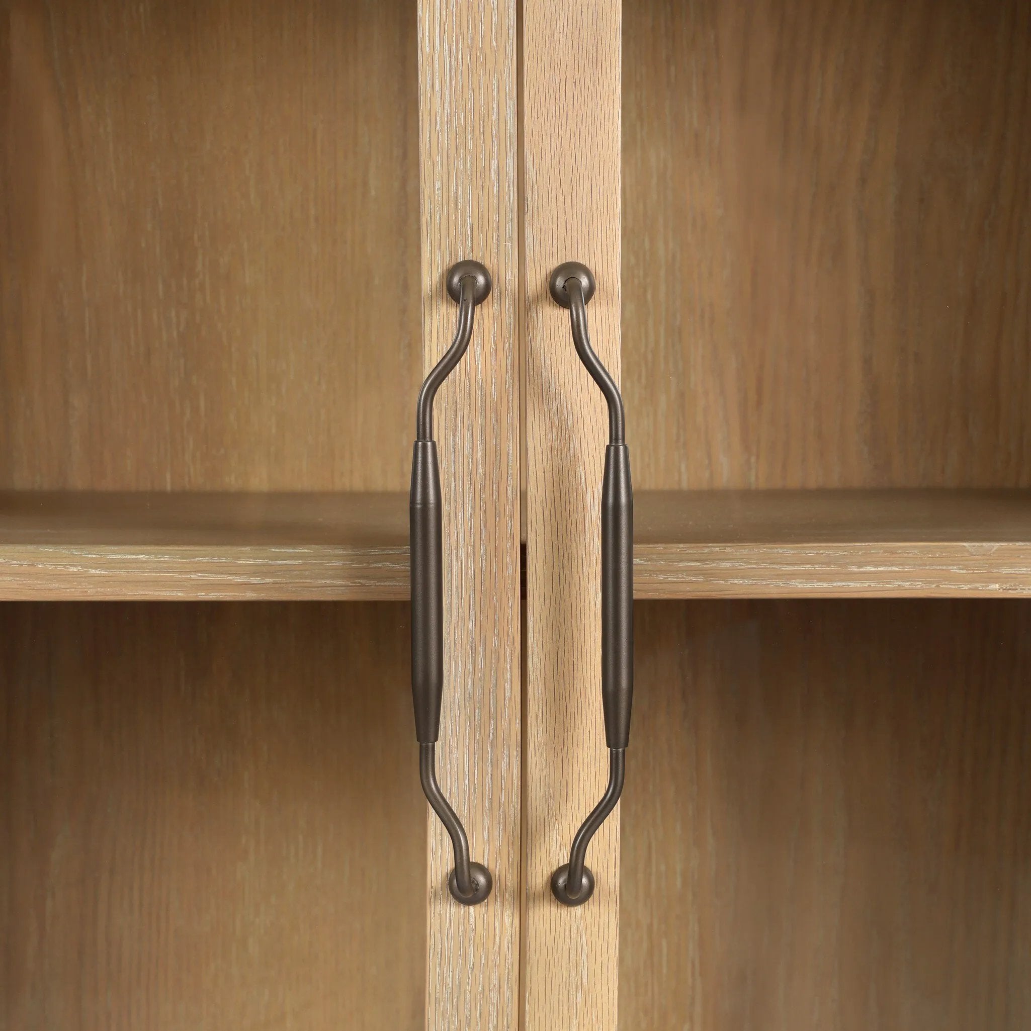 Traditional design defines this light-finished oak cabinet. Simple, clean side panels highlight a softly curved bottom frame. Steel handles in a copper patina finish add a unique touch.As fans of wabi sabi design at Amethyst, we love the nature inspired Gates Cabinet - Light Natural Oak Veneer. Amethyst Home provides interior design, new home construction design consulting, vintage area rugs, and lighting in the Des Moines metro area.