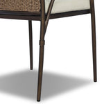 This outdoor dining chair takes inspiration from classic French bistro-style chairs, featuring a distinctive metal collar detail on the arms. The woven seatback comes together in a diamond pattern, finished with a cream-colored seat cushion. Cover or store inside during inclement weather and when not in use. Amethyst Home provides interior design, new home construction design consulting, vintage area rugs, and lighting in the Austin metro area.