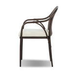 This outdoor dining chair takes inspiration from classic French bistro-style chairs, featuring a distinctive metal collar detail on the arms. The woven seatback comes together in a diamond pattern, finished with a cream-colored seat cushion. Cover or store inside during inclement weather and when not in use. Amethyst Home provides interior design, new home construction design consulting, vintage area rugs, and lighting in the Miami metro area.