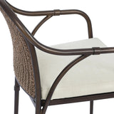 This outdoor dining chair takes inspiration from classic French bistro-style chairs, featuring a distinctive metal collar detail on the arms. The woven seatback comes together in a diamond pattern, finished with a cream-colored seat cushion. Cover or store inside during inclement weather and when not in use. Amethyst Home provides interior design, new home construction design consulting, vintage area rugs, and lighting in the Monterey metro area.