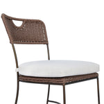 A light, airy take on the traditional bistro shape. This outdoor dining chair features exaggerated splayed legs and a curved X-shaped stretcher, with a handle detail cut out of the woven seat back. Finished with a seat cushion. Cover or store indoors during inclement weather and when not in use. Amethyst Home provides interior design, new home construction design consulting, vintage area rugs, and lighting in the Dallas metro area.
