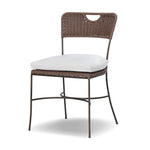 A light, airy take on the traditional bistro shape. This outdoor dining chair features exaggerated splayed legs and a curved X-shaped stretcher, with a handle detail cut out of the woven seat back. Finished with a seat cushion. Cover or store indoors during inclement weather and when not in use. Amethyst Home provides interior design, new home construction design consulting, vintage area rugs, and lighting in the Nashville metro area.