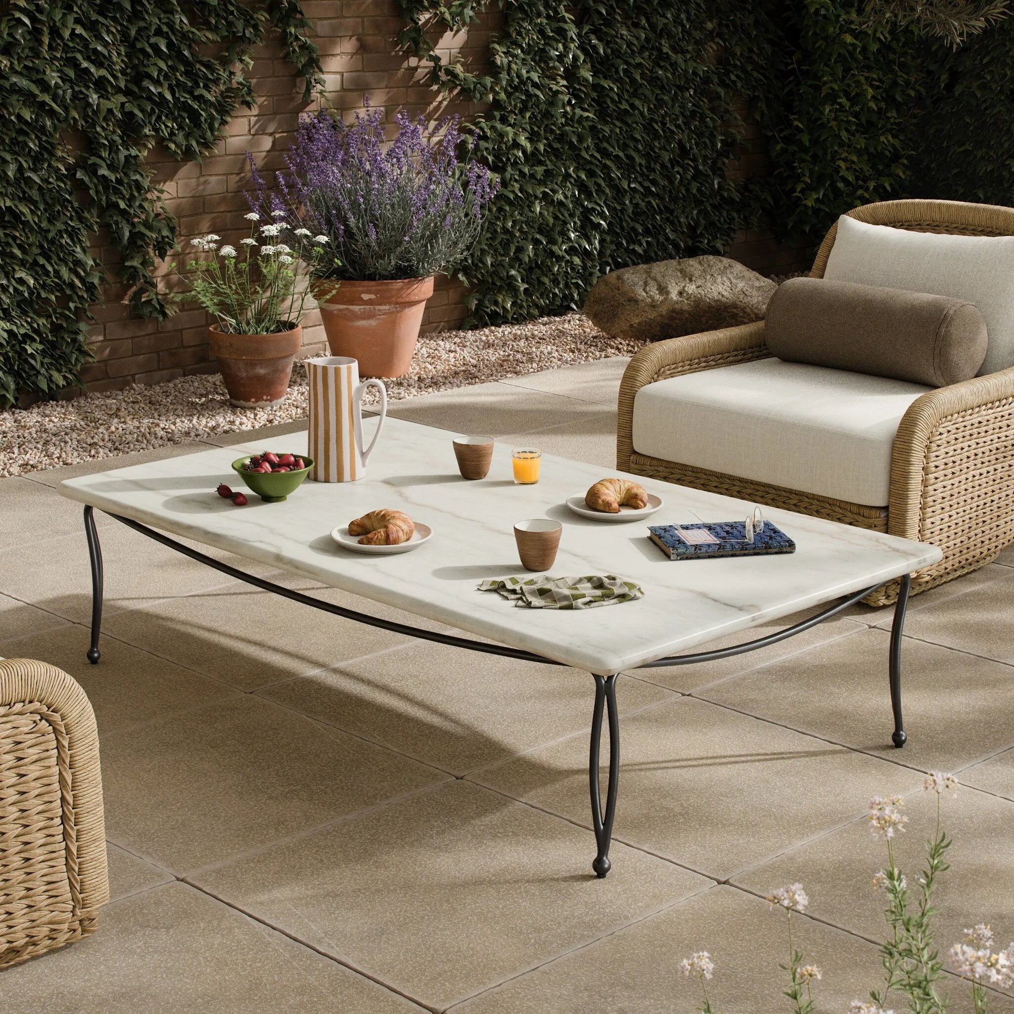 Inspired by Art Deco designs, this outdoor coffee table introduces a sense of movement to a classic silhouette. Graceful, flowing lines on the base pair with a white marble top for a classic black-and-white look. Cover or store inside during inclement weather and when not in use. Amethyst Home provides interior design, new home construction design consulting, vintage area rugs, and lighting in the Scottsdale metro area.