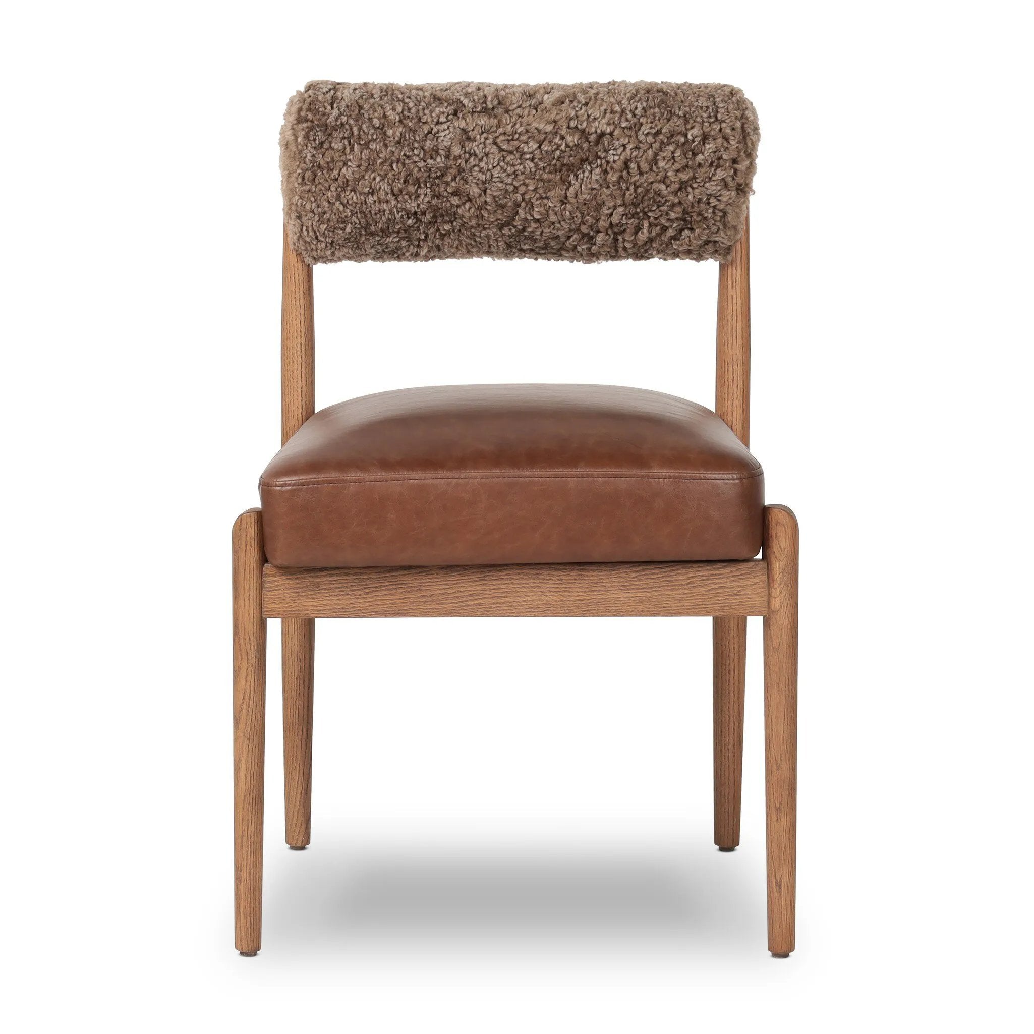 The armless dining chair gets a playful update with mixed materials and a bolstered cylinder seat back. Inspired by midcentury and Seventies styling and made from solid oak, top-grain leather  and soft shearling to elevate your bar, kitchen or dining space Amethyst Home provides interior design, new home construction design consulting, vintage area rugs, and lighting in the Winter Garden metro area.