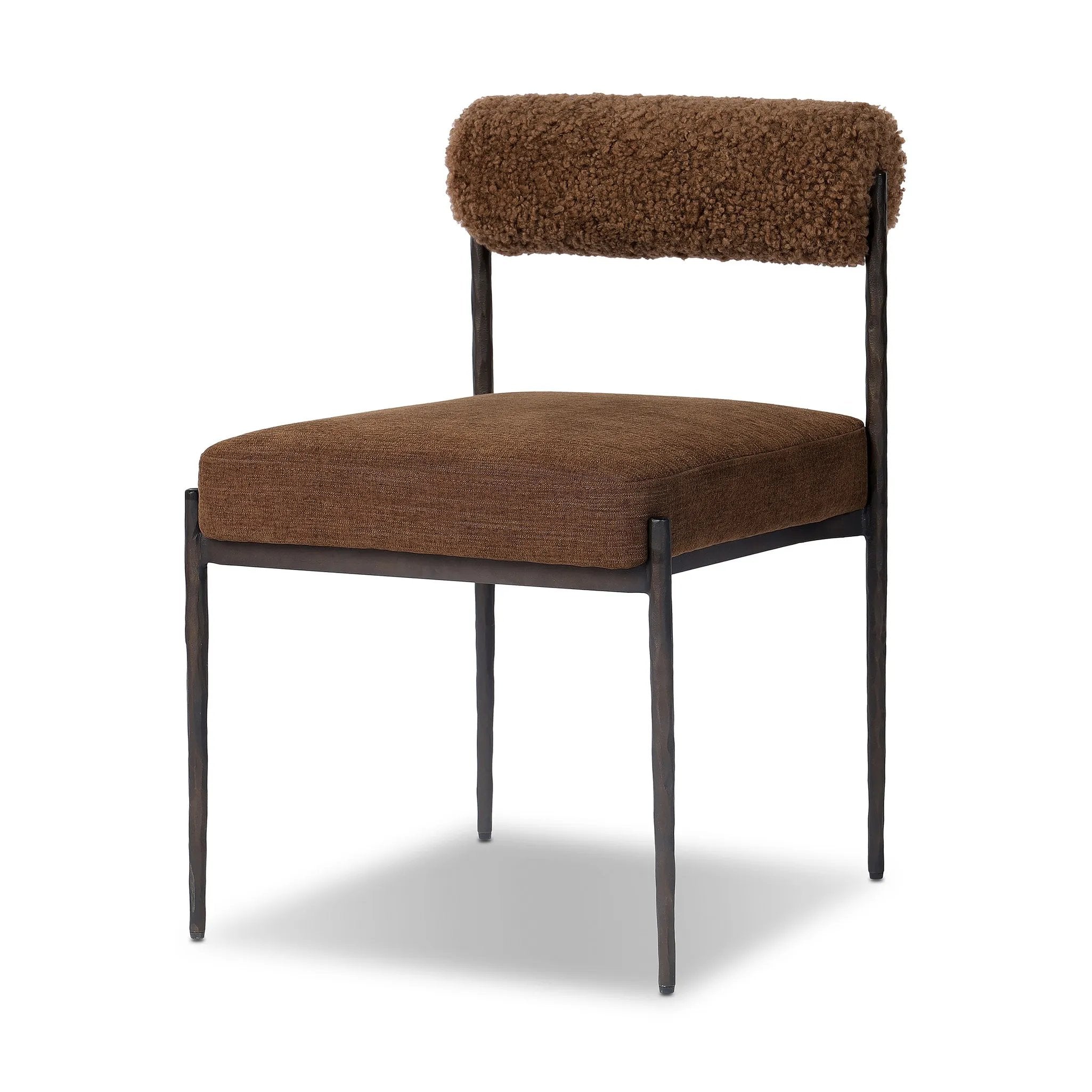 The armless dining chair gets a playful update with a bolstered cylinder seat back. Made from soft shearling and hammered met