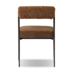The armless dining chair gets a playful update with a bolstered cylinder seat back. Made from soft shearling and hammered met