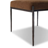 The armless dining chair gets a playful update with a bolstered cylinder seat back. Made from soft shearling and hammered met