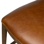 Bring a mixed-material look to the counter. Brown-finished solid oak shapes a curved seat back and sturdy frame for comfy seating upholstered with top-grain leather exclusive to Four Hands. A "handle" opening at the top of the seat back brings a touch of lightness to the look. Amethyst Home provides interior design, new home construction design consulting, vintage area rugs, and lighting in the Charlotte metro area.