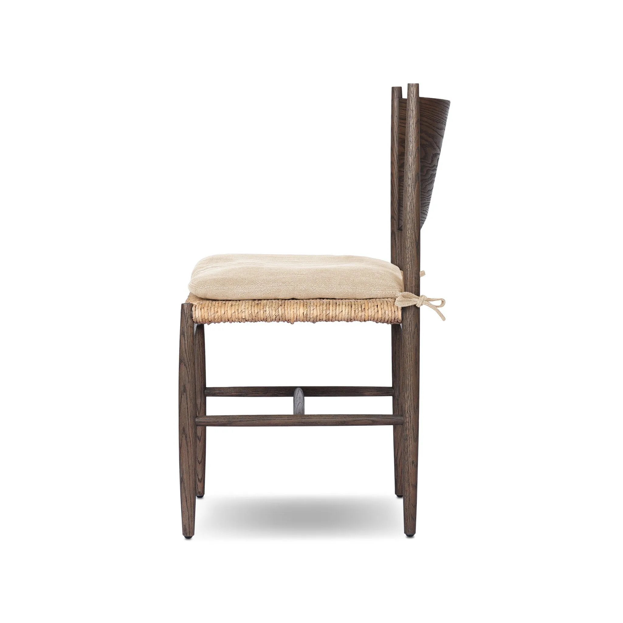 A seamless addition to your dining collection, a slim-profile dining chair pairs a woven banana leaf seat with a solid oak frame featuring a bentwood back. A tie-fasten seat cushion of high-performance fabric completes the look. Amethyst Home provides interior design, new home construction design consulting, vintage area rugs, and lighting in the Newport Beach metro area.