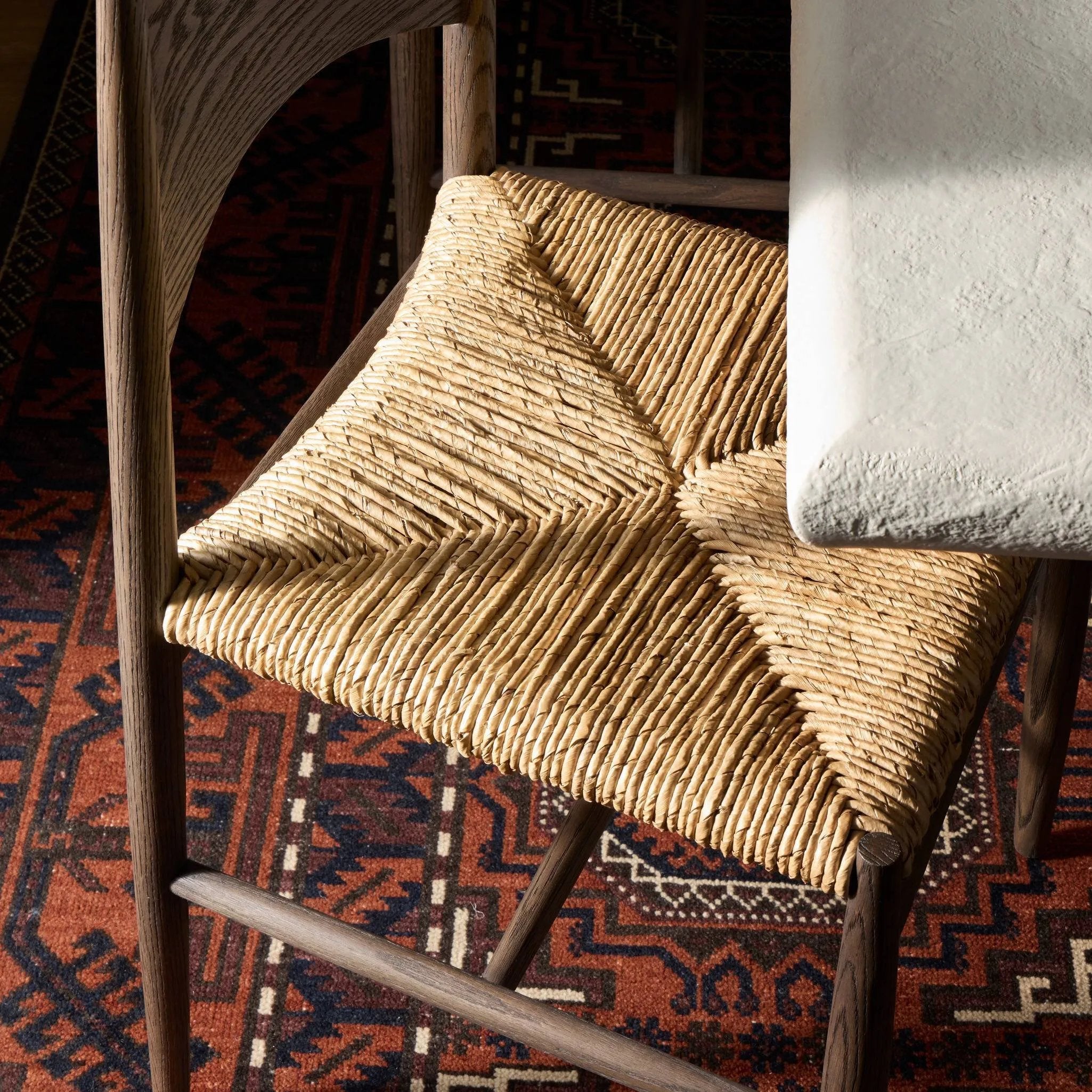 Featuring Jovan Stained Saddle Brown Dining Chair by Four Hands at Amethyst Home. A seamless addition to your dining collection, a slim-profile dining chair pairs a woven banana leaf seat with a solid oak frame featuring a bentwood back. Overall Dimensions: 20.00"w x 22.25"d x 37.00"h. Amethyst Home provides interior design, new home construction design consulting, vintage area rugs, and lighting in the Kansas City metro area.
