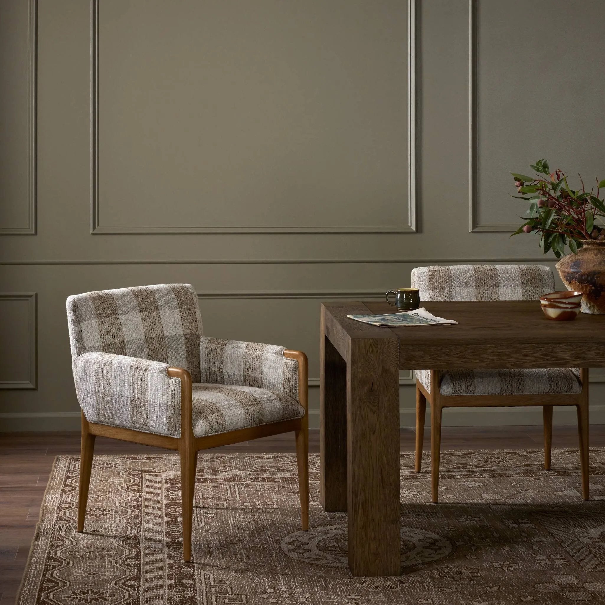 A patterned dining chair that’s all about comfort. Checkered-print upholstery is framed by light, warm oak, while a boxy profile and higher arms feel prime for the head of the table Amethyst Home provides interior design, new home construction design consulting, vintage area rugs, and lighting in the Nashville metro area.