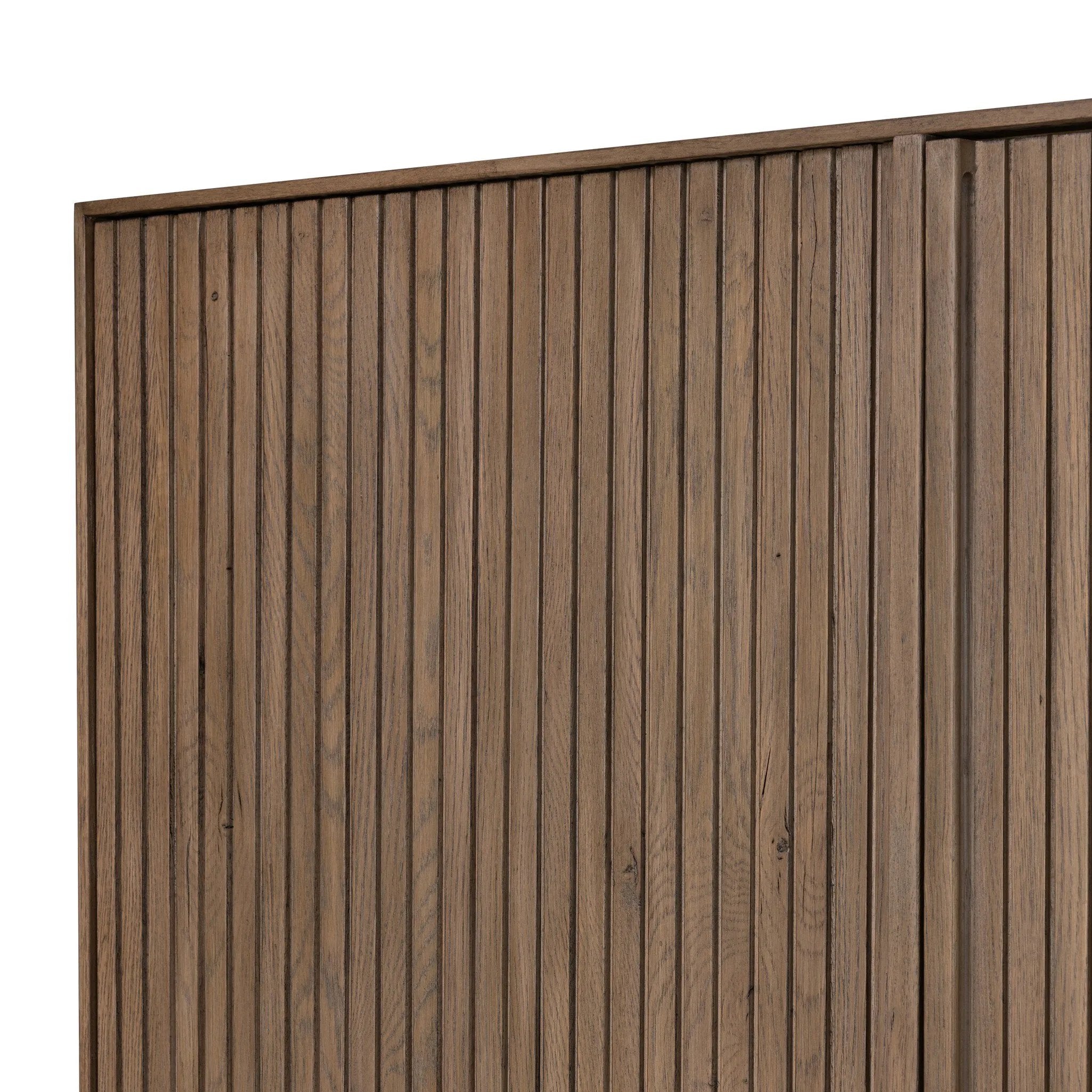 Made from rustic-finished oak with a plinth-style base, clean angles and linear reeding define this midcentury-spirited cabinet. Fully finished interior for a beautiful look inside and out. Designed in partnership with longtime Four Hands collaborator Thomas Bina and Brazilian designer Ronald Sasson. Amethyst Home provides interior design, new home construction design consulting, vintage area rugs, and lighting in the Austin metro area.