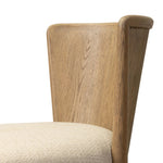 The barrel back dining chair, refreshed. Light oak shapes an armless frame and curved rear legs that almost appear to flow into the seat back. A comfy seat is upholstered in high-performance fabric, while reeding details on the back create a sense of perception play. Amethyst Home provides interior design, new home construction design consulting, vintage area rugs, and lighting in the Los Angeles metro area.