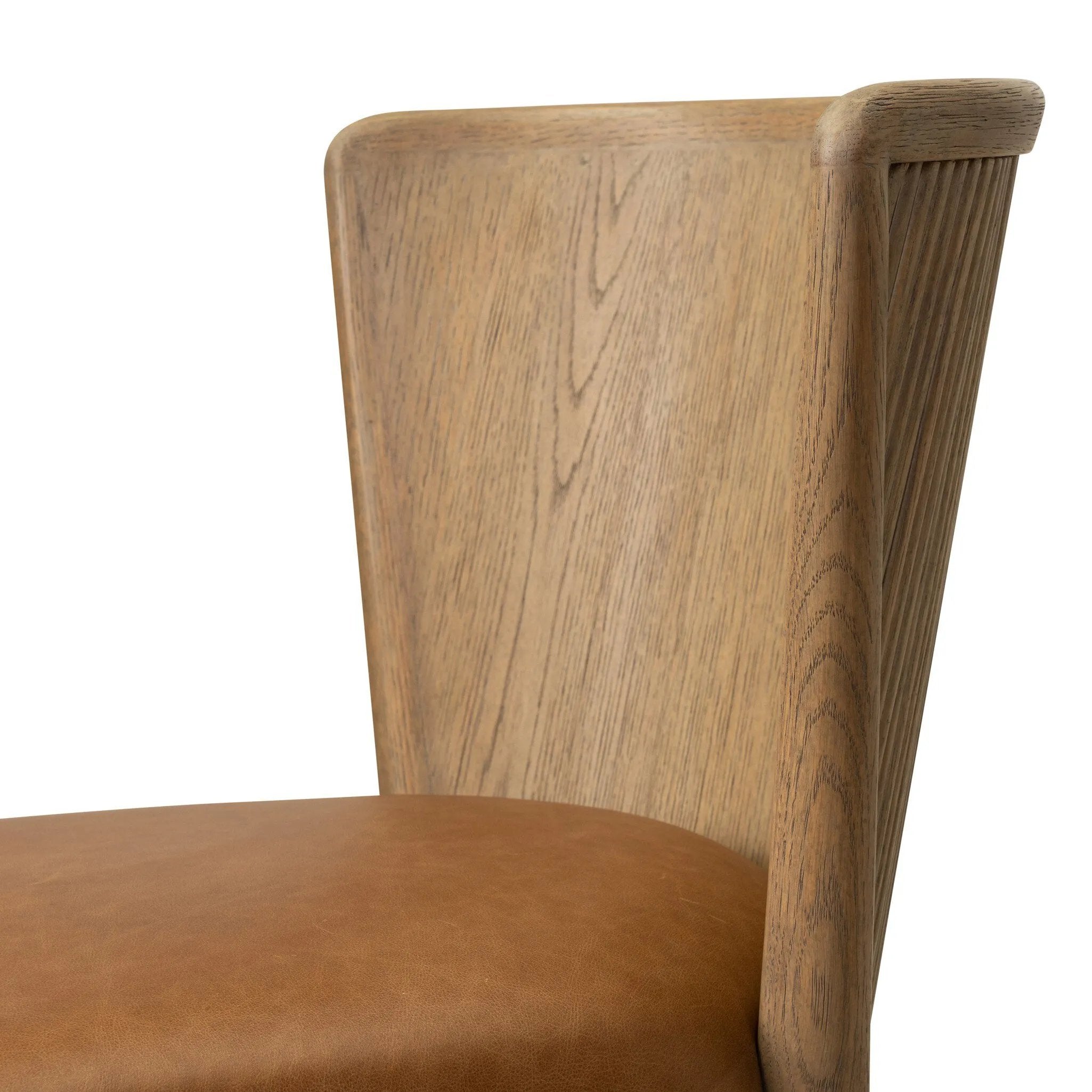 The barrel back dining chair, refreshed. Light oak shapes an armless frame and curved rear legs that almost appear to flow into the seat back. A comfy seat is upholstered in chestnut top-grain leather, while reeding details on the back create a sense of perception play. Amethyst Home provides interior design, new home construction design consulting, vintage area rugs, and lighting in the Austin metro area.