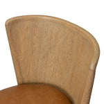 The barrel back dining chair, refreshed. Light oak shapes an armless frame and curved rear legs that almost appear to flow into the seat back. A comfy seat is upholstered in chestnut top-grain leather, while reeding details on the back create a sense of perception play. Amethyst Home provides interior design, new home construction design consulting, vintage area rugs, and lighting in the Nashville metro area.