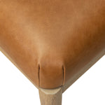 The barrel back dining chair, refreshed. Light oak shapes an armless frame and curved rear legs that almost appear to flow into the seat back. A comfy seat is upholstered in chestnut top-grain leather, while reeding details on the back create a sense of perception play. Amethyst Home provides interior design, new home construction design consulting, vintage area rugs, and lighting in the Seattle metro area.