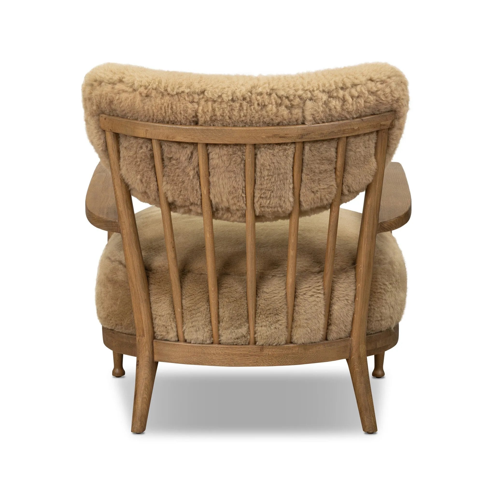 Classic Scandinavian design gets a supersoft update with a winged back panel of amber-finished oak floating above a chunky seat with exposed spindles. Paddle arms and ball feet add to the minimalist design. Covered in natural beige shearling for extra texture and comfort Amethyst Home provides interior design, new home construction design consulting, vintage area rugs, and lighting in the Alpharetta metro area.