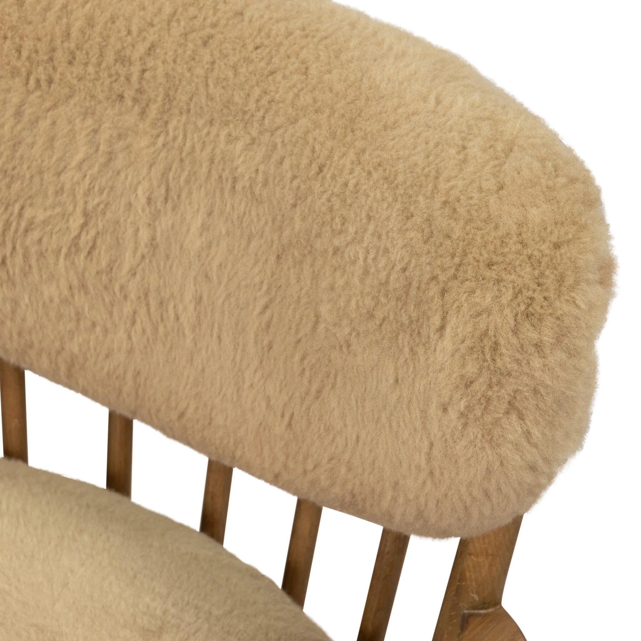 Classic Scandinavian design gets a supersoft update with a winged back panel of amber-finished oak floating above a chunky seat with exposed spindles. Paddle arms and ball feet add to the minimalist design. Covered in natural beige shearling for extra texture and comfort Amethyst Home provides interior design, new home construction design consulting, vintage area rugs, and lighting in the Boston metro area.