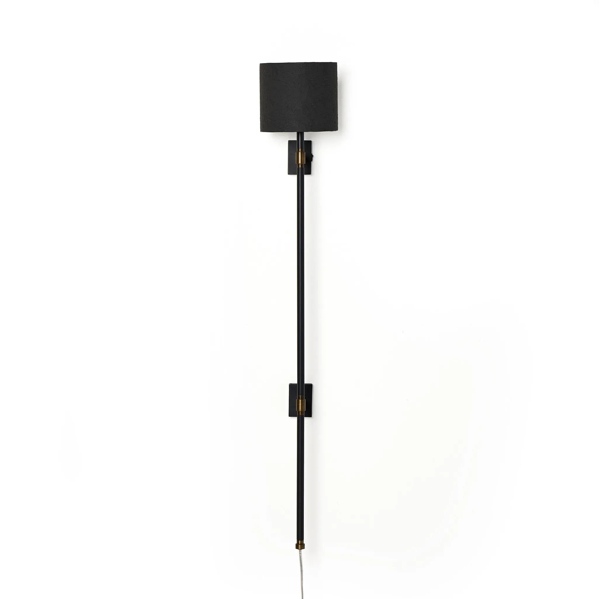 Featuring Maurice Matte Black Plaster Sconce by Four Hands at Amethyst Home. Housed behind a curved black shade, light beams with a soft glow both upward and downward from this plug-in sconce.  A  slim pole to hide the cord and a convenient switch on the backplate create a seamless look.Overall Dimensions: 8.00"w x 7.50"d x 50.00"hWeight : 6.61 lbsMaterials: . Amethyst Home provides interior design, new home construction design consulting, vintage area rugs, and lighting in the Houston metro area.